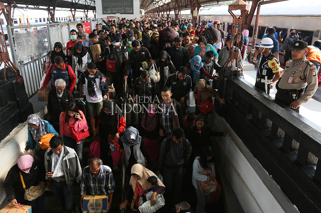 Para penumpang arus balik KA Kertajaya, Surabaya Pasar Turi-Jakarta Pasar Senen tiba di Stasiun Senen, Jakarta.