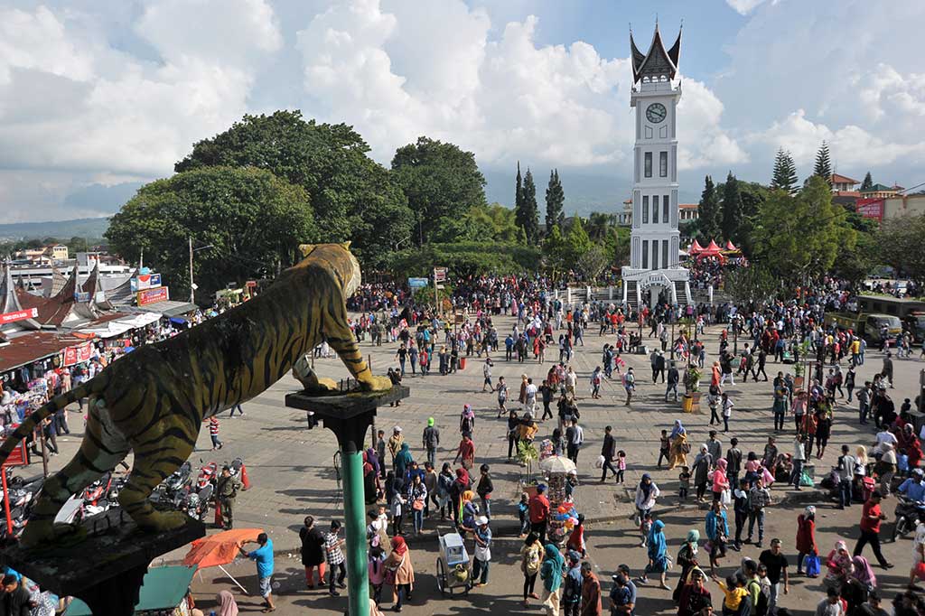 Pengunjung menikmati objek wisata Jam Gadang, di Bukittinggi, Sumatera Barat. ANTARA/Iggoy el Fitra