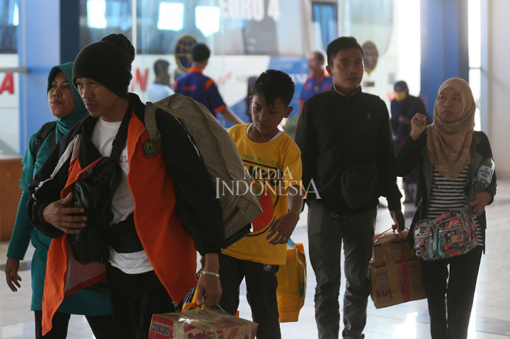 Pemudik membawa barang bawaannya saat tiba di Terminal Pulo Gebang, Jakarta Timur.