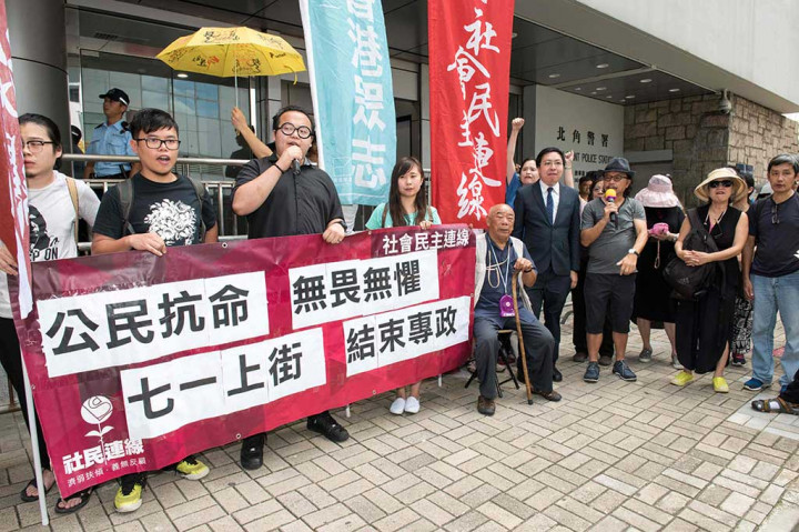 Aktivis prodemokrasi  berunjuk rasa di luar sebuah kantor polisi di Hong Kong, Kamis, untuk mendukung demonstran yang ditahan saat melakukan demonstrasi di patung Golden Bauhinia.