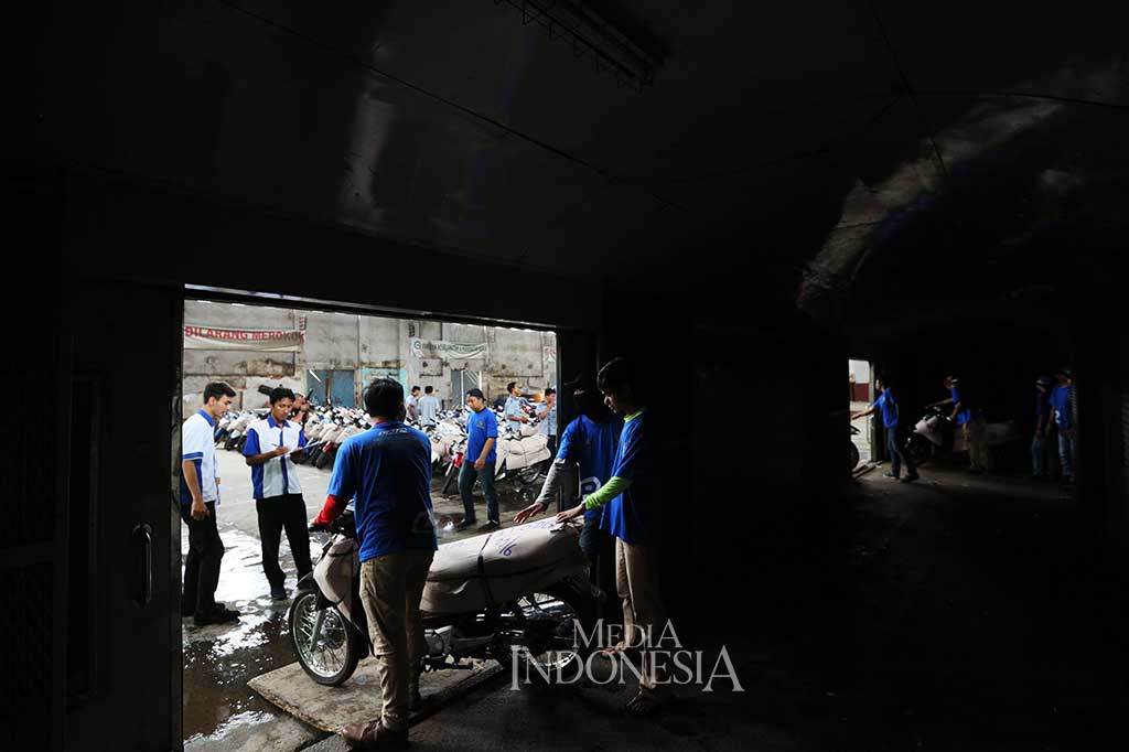 Petugas melakukan bongkar muat sepeda motor milik pemudik yang mengikuti program pengangkutan motor gratis mudik dan balik, dari dalam gerbong barang rangkaian kereta Lintas Selatan 1 di Stasiun Jakarta Gudang, Kampung Bandan, Jakarta, Jumat (30/6/2017).