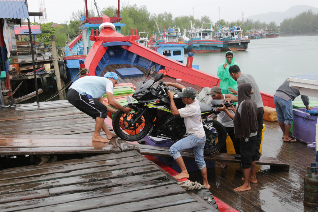 Sebuah sepeda motor pemudik dikeluarkan dari kapal kayu di dermaga Lampulo, Banda Aceh, Aceh. Arus balik pemudik meningkat sejak hari keempat lebaran dan diperkirakan puncaknya pada Sabtu, 1 Juli 2017. ANTARA FOTO/Irwansyah Putra