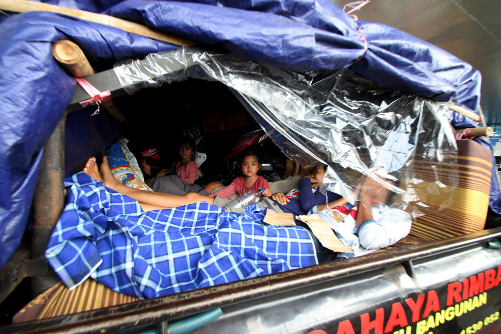 Serombongan keluarga menggunakan mobil bak terbuka di Gerbang Tol Cikarang Utama. Walau tidak aman dan tidak nyaman, namun mudik dengan mobil bak terbuka masih sering terlihat karena terhitung murah-meriah dan praktis. Antara Foto/Rivan Lingga 