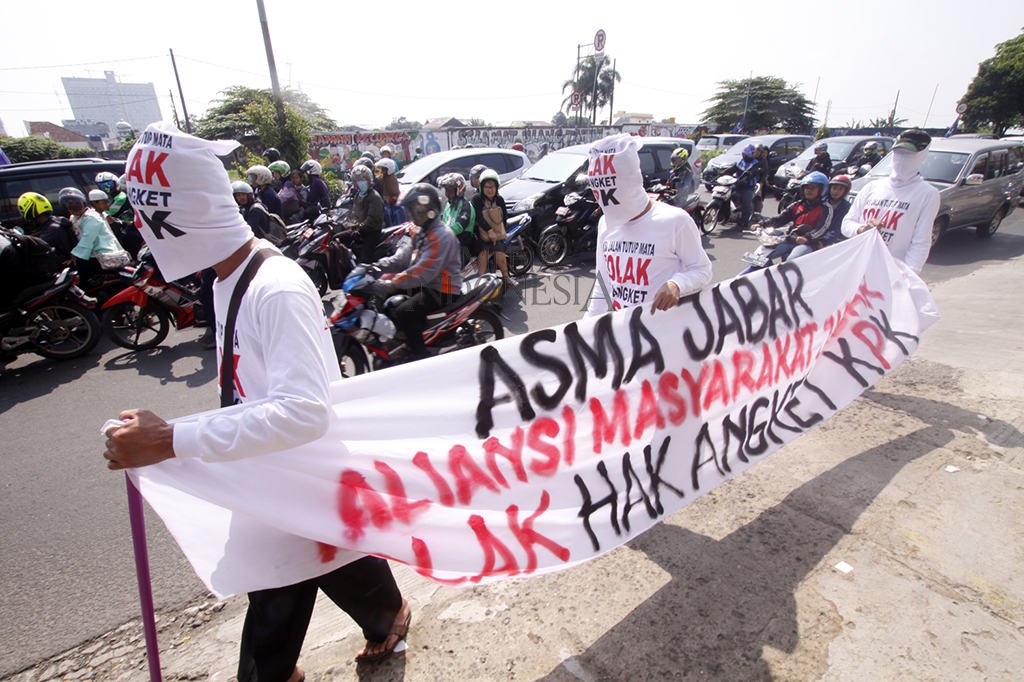 Para pengunjukrasa mengenakan kaos putih dan memegang spanduk bertuliskan 'Aliansi Masyarkarat Jawa Barat tolak Hak Angket KPK' sebagai bentuk dukungan kepada KPK.