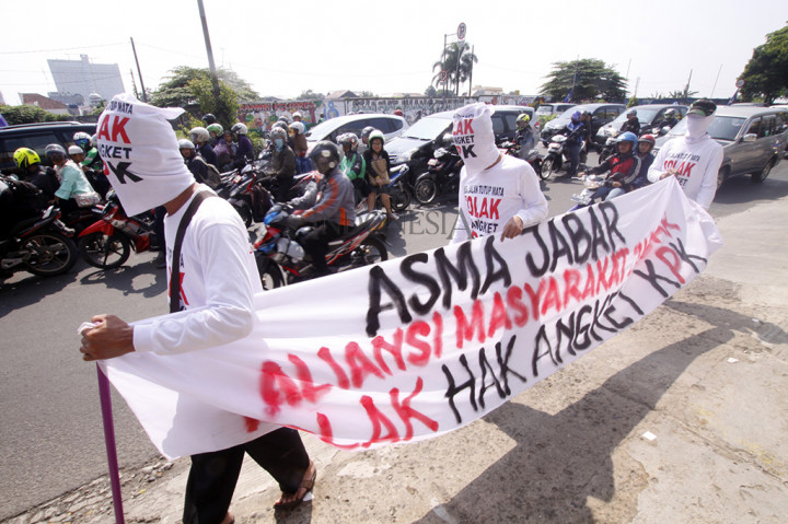 Para pengunjukrasa mengenakan kaos putih dan memegang spanduk bertuliskan 'Aliansi Masyarkarat Jawa Barat tolak Hak Angket KPK' sebagai bentuk dukungan kepada KPK.