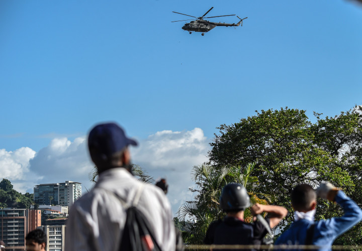 Pengunjukrasa mengamati helikopter militer Venezuela yang berputar-putar di atas Caracas. Militer juga menerbangkan jet tempur Sukhoi Su-30MKV dan Karakorum Hongdu K-8. 