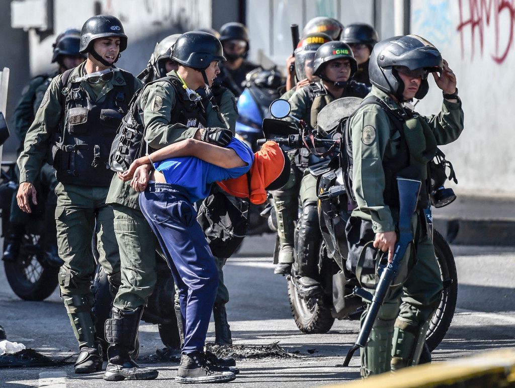 Polisi anti huru-hara membekuk seorang pengunjukrasa yang melempari mereka dengan bom molotov. Massa pengunjuk rasa menilai Presiden Moduro lambat menangani krisis ekonomi panjang yang dipicu rendahnya harga minyak bumi.