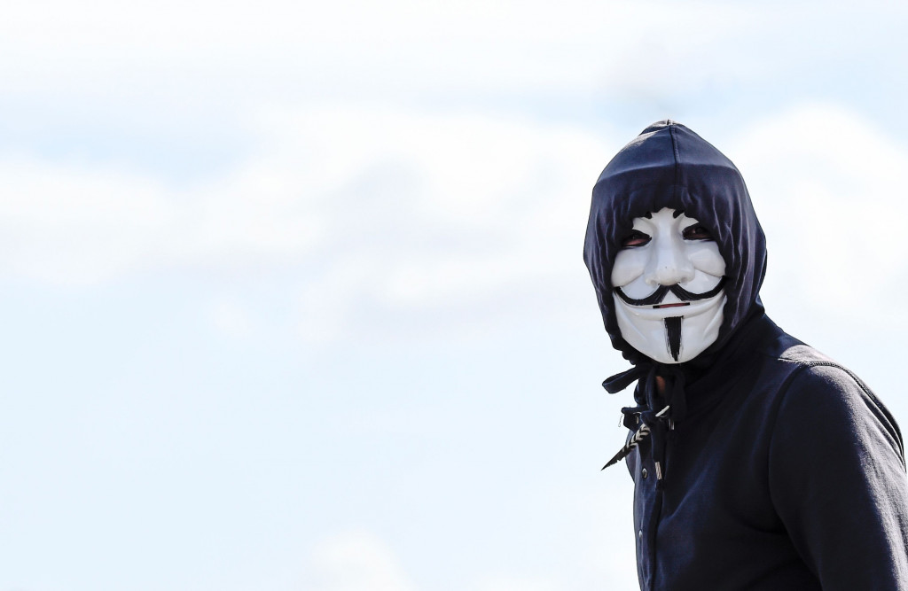 Seorang pengunjuk rasa mengenakan topeng ikonik yang populer lewat film V for Vendetta. Krisis ekonomi panjang telah menyebabkan jumlah pengangguran dan tindak kriminalitas di berbagai wilayah.  