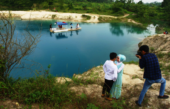 Sepasang calon pengantin berfoto pre-wedding dengan latar belakang Danau Biru. Warna air yang biru di lobang bekas galian tambang pasir itu berasal dari proses alam. ANTARA FOTO/Muhammad Iqbal