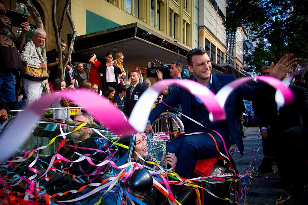 Ribuan warga antusias menyambut pahlawan mereka tersebut di pinggir jalan Queen Street Mall Brisbane saat arak-arakan Horn lewat dengan mobil sport antik bersama istrinya.