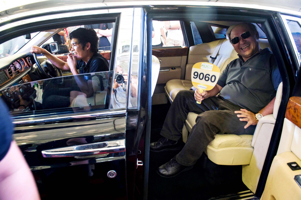 Seorang warga berpose di dalam Rolls Royce yang berhasil dia menangkan lelangnya. 