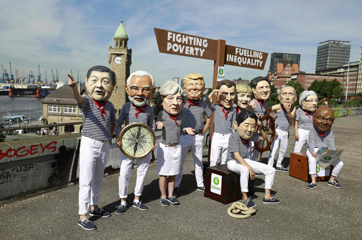 Sementara itu aktivis anti kapitalis melakukan aksi dengan mengenakan topeng para pimpinan negara G20 di Hamburg, Jerman Utara, Kamis (6/7/2017). Salah satu poin yang diserukan mereka adalah kesetaraan dan menutup jurang antara kaya dan miskin. 