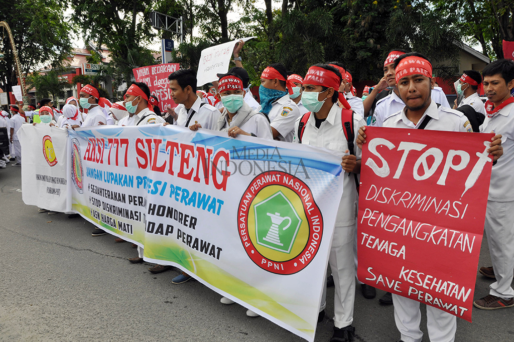 Sejumlah perawat honorer memegang poster dan spanduk saat menggelar unjuk rasa di depan kantor Dewan Perwakilan Rakyat Daerah (DPRD) Sulawesi Tengah di Palu.