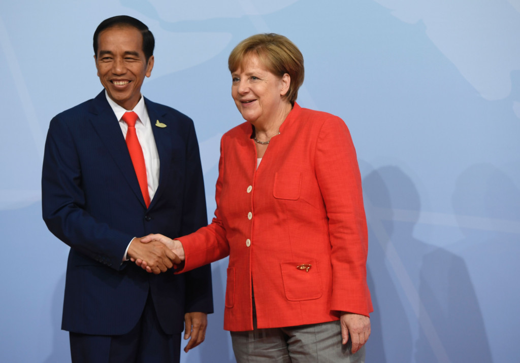 Presiden Jokowi disambut Kanselir Jerman Angela Merkel setibanya di gedung tempat berlangsungnya KTT G20. Forum tahunan ini dihadiri 21 kepala pemerintahan negara maju dan emerging ekonomi. AFP PHOTO / SAUL LOEB