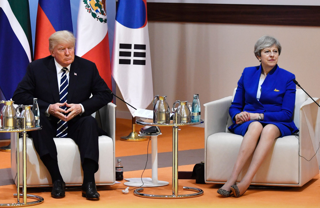 Presiden AS Donald Trump dan PM Inggris Theresa May duduk berdampingan. Di dalam kampanyenya semasa Pilpres AS, Trump mengusung isu anti pasar bebas dan menolak akui sedang terjadi pemanasan global akibat industri yang massif. AFP PHOTO AND POOL / John MACDOUGALL
 