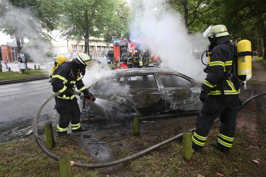 Sebuah mobil yang dibakar massa pengunjukrasa sedang dipadamkan oleh petugas. Gelombang unjuk rasa terjadi di beberapa tempat sekaligus di Hamburg sejak tiga hari lalu. AFP PHOTO / DPA / Bodo Marks 