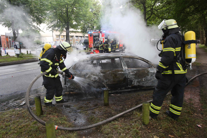 Sebuah mobil yang dibakar massa pengunjukrasa sedang dipadamkan oleh petugas. Gelombang unjuk rasa terjadi di beberapa tempat sekaligus di Hamburg sejak tiga hari lalu. AFP PHOTO / DPA / Bodo Marks 