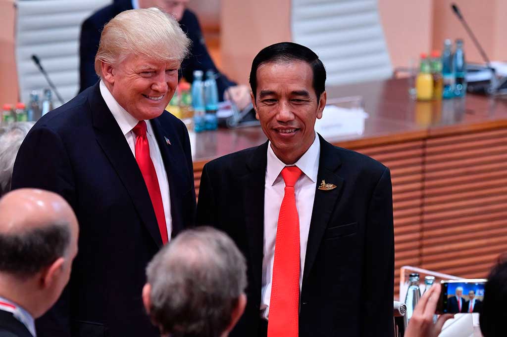 Trump dan Jokowi berpose saat diabadikan oleh delegasi lain, di sela-sela  KTT G20.