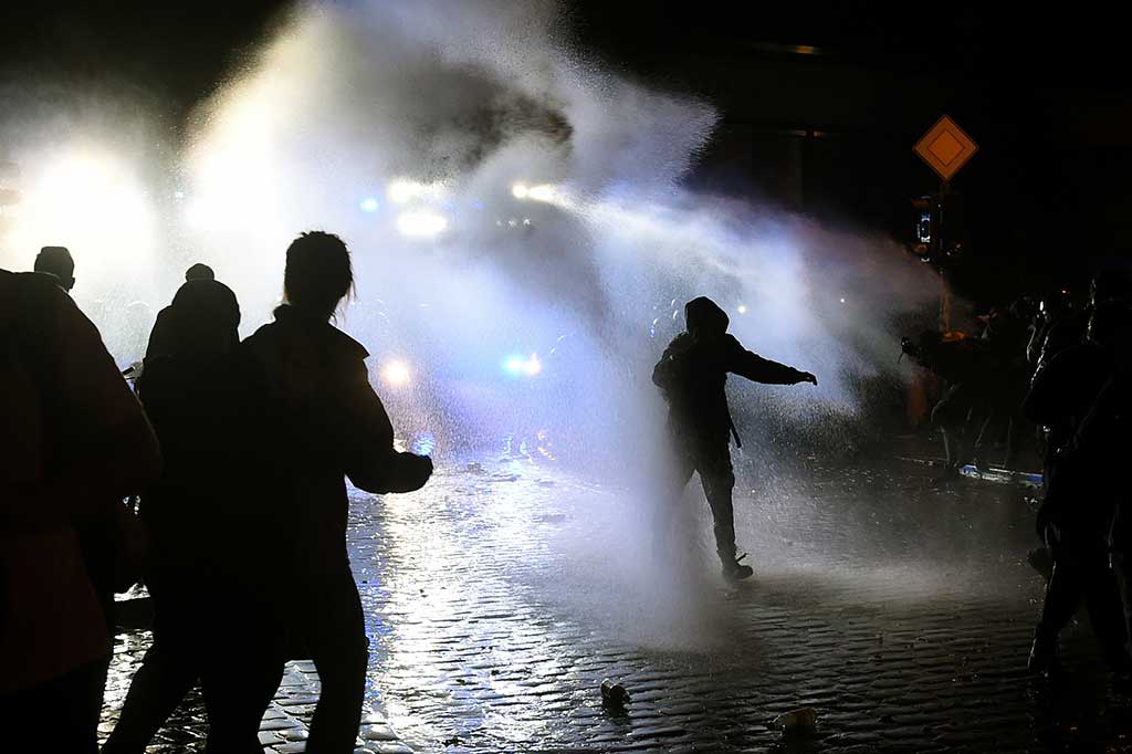 Polisi terpaksa menggunakan water cannon untuk membubarkan massa yang masih berkerumun.