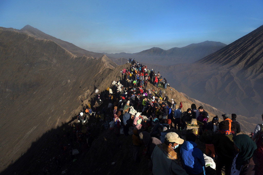 Ratusan warga Tengger dan wisatawan berdesakan di bibir kawah mengikuti puncak ritual Nyadnya Kasada. Ritual ini selalu menarik perhatian wisatawan, termasuk dari luar negeri.