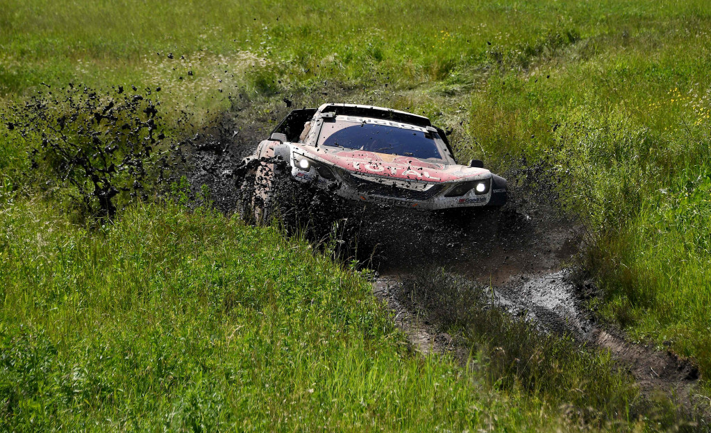 Dibantu oleh Daniel Elena, pereli Sebastien Loeb berjuang membebaskan Peugeot pacuannya dari kubangan lumpur yang dalam. 