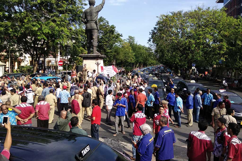 Ratusan sopir taksi konvensional memenuhi Bundaran Gladag, Jl Slamet Riyadi, Solo, Jateng, Selasa (11/7/2017). Mereka menggelar aksi damai menolak operasional taksi berbasik aplikasi atau taksi online di wilayah Solo Raya.