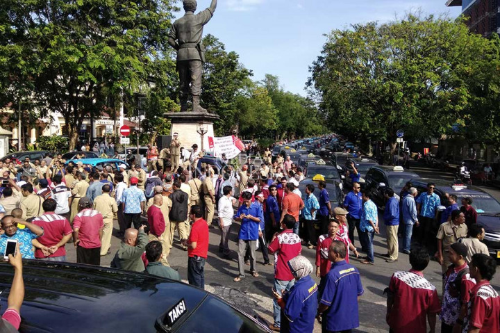 Ratusan sopir taksi konvensional memenuhi Bundaran Gladag, Jl Slamet Riyadi, Solo, Jateng, Selasa (11/7/2017). Mereka menggelar aksi damai menolak operasional taksi berbasik aplikasi atau taksi online di wilayah Solo Raya.