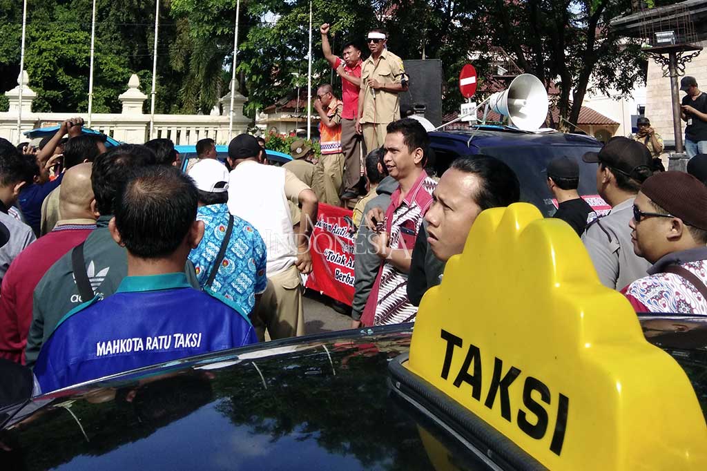 Menurut mereka adanya angkutan umum berbasis aplikasi tersebut sangat merugikan taksi yang dilindungi Undang Undang Lalu Lintas itu. Dengan adanya taksi online pendapatan mereka bisa berkurang hingga sekitar 50%.