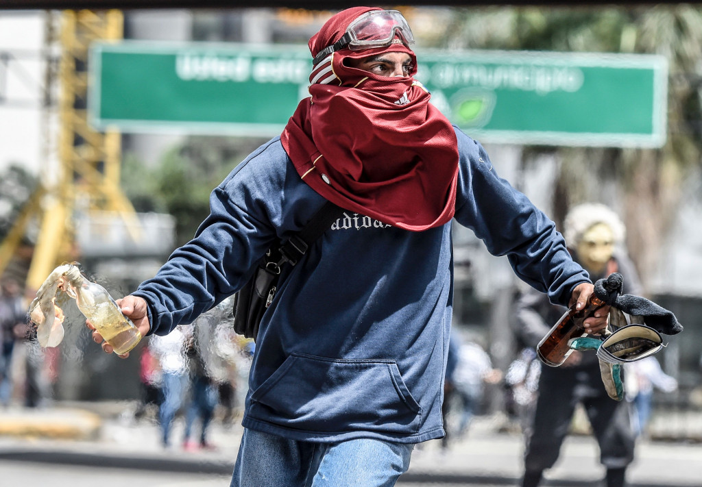 Seorang pengunjuk rasa di Caracas bersiap melemparkan molotov ke barikade polisi anti huru-hara. Krisis ekonomi dipicu melemahnya harga minyak yang selama ini menjadi andalan pendapatan Venezuela. AFP PHOTO / JUAN BARRETO