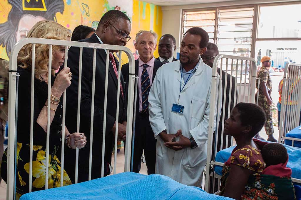 Bintang pop AS Madonna (kiri) didampingi Presiden Malawi Arthur Peter Mutharika (kedua kiri) mengunjungi salah satu bangsal Rumah Sakit Anak Mercy James, saat peresmiannya, di Blantyre, Malawi, Selasa (11/7/2017) waktu setempat.