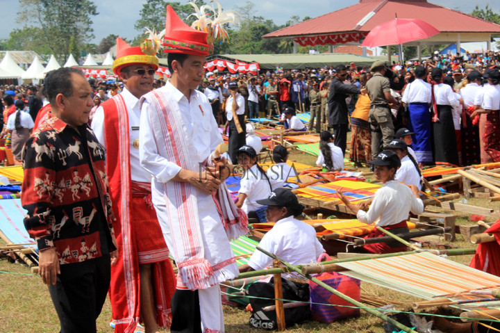 Presiden Joko Widodo mengenakan pakaian adat Sumba bersama Gubernur Nusa Tenggara Timur Frans Lebu Raya  dan Bupati Sumba Barat Daya Markus Dairo Talu meninjau peserta festival tenun ikat tradisional Sumba di Lapangan Galatama Tambolaka.