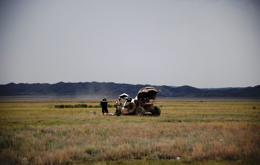 Seorang warga menonton pereli sedang memperbaiki UTV Polaris 4x4 pacuannya yang didera masalah. Melaju di dataran padang rumput luas ini bukan perkara yang gampang.