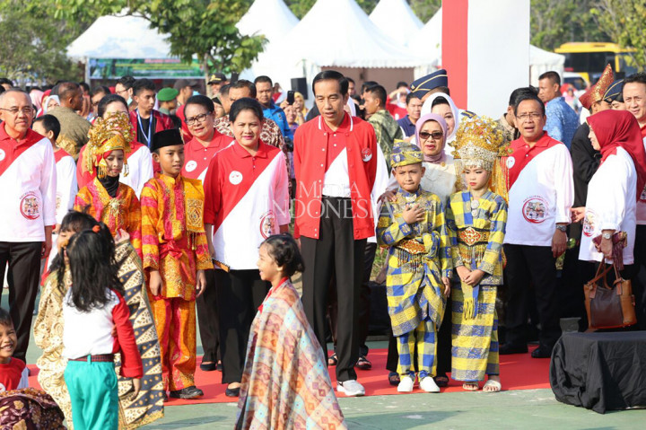 Jokowi dan Ibu Negara Iriana Joko Widodo yang mengenakan jaket dan kaus Hari Anak Nasional 2017 warna merah putih, tiba di Lapangan Gedung Daerah Pauhjanggi Provinsi Riau.