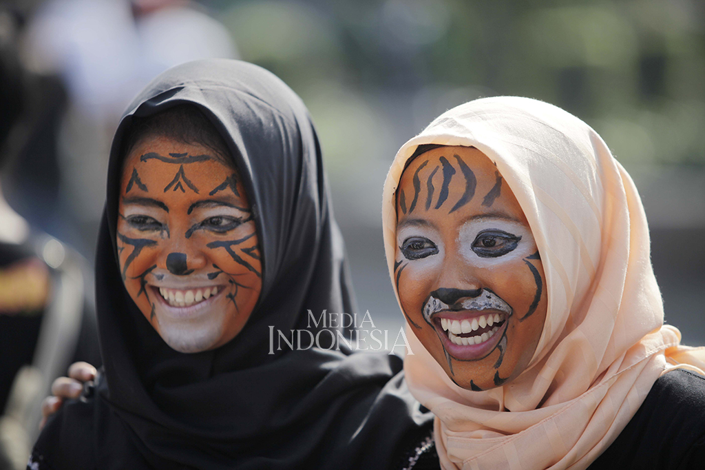 Para peserta aksi merias wajahnya menyerupai harimau sebagai simbol peringatan hari harimau sedunia.