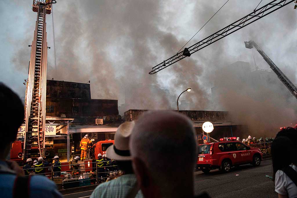 Petugas pemadam kebakaran berjibaku memadamkan kebakaran yang melanda pasar ikan Tsukiji di Tokyo, Kamis (3/8/2017) sore waktu setempat.