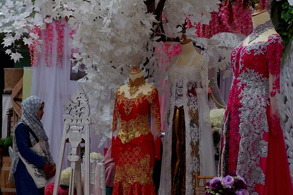 Seorang pengunjung melintas di dekat patung peraga berbusana pengantin tradisional modifikasi, pada pameran Pernikahan Tradisional 2017 di Semarang, Jawa Tengah, Jumat (4/8/2017).
