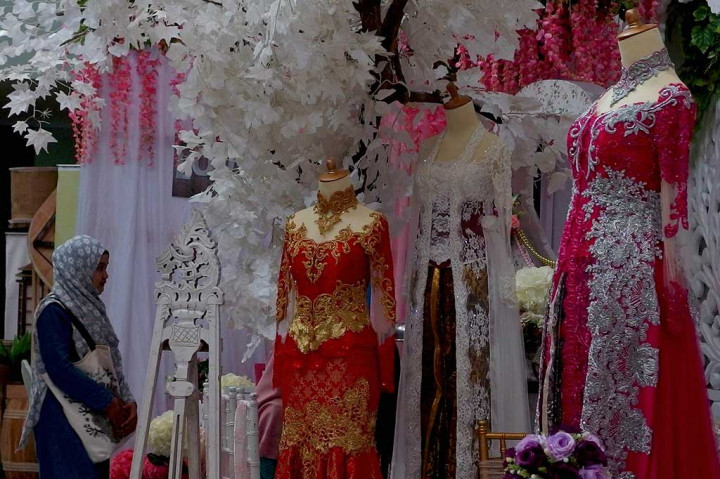 Seorang pengunjung melintas di dekat patung peraga berbusana pengantin tradisional modifikasi, pada pameran Pernikahan Tradisional 2017 di Semarang, Jawa Tengah, Jumat (4/8/2017).