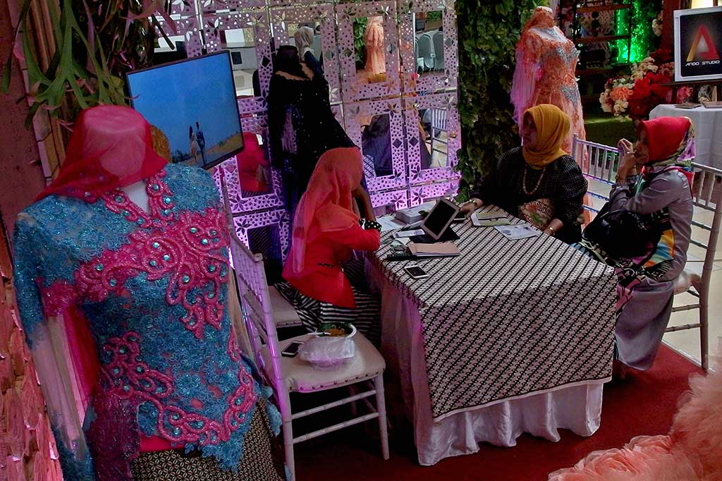 Penjaga stan memberikan informasi tentang produk dan jasa acara pernikahan kepada pengunjung pada pameran Pernikahan Tradisional 2017 di Semarang.