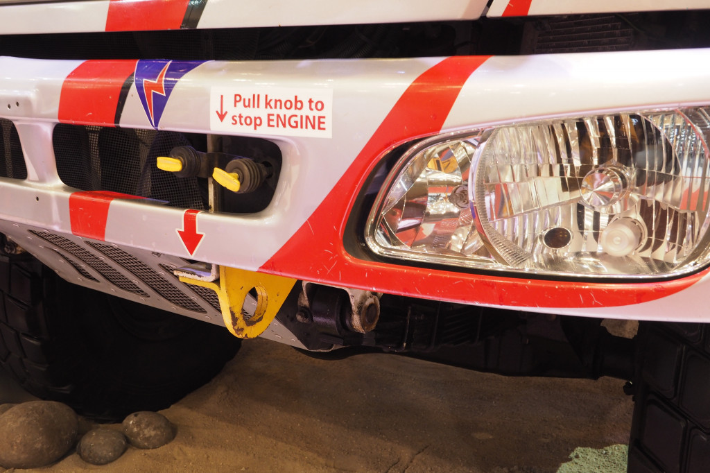 Tuas pemutus arus listrik untuk mematiikan mesin berada di bumper depan. Walau kecil, tetapi perannya sangan besar bagi keselamatan ketika terjadi musibah.