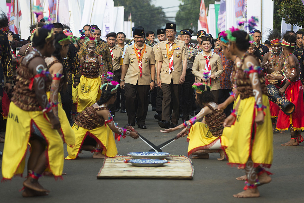 Presiden Joko Widodo  berjalan bersama Ibu Negara Iriana Joko Widodo dan Ketua Kwartir Nasional Gerakan Pramuka Adhyaksa Dault mengikuti prosesi Raimuna Nasional XI yang bertepatan dengan peringatan ulang tahun Pramuka ke-56 di, Bumi Perkemahan Cibubur, Jakarta.