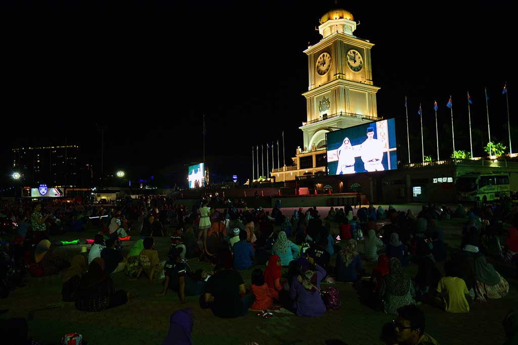 Warga menyaksikan seremoni pernikahan putri Sultan Johor lewat layar lebar yang dipasang di Dataran Bandaraya (alun-alun kota) di Johor Baru.