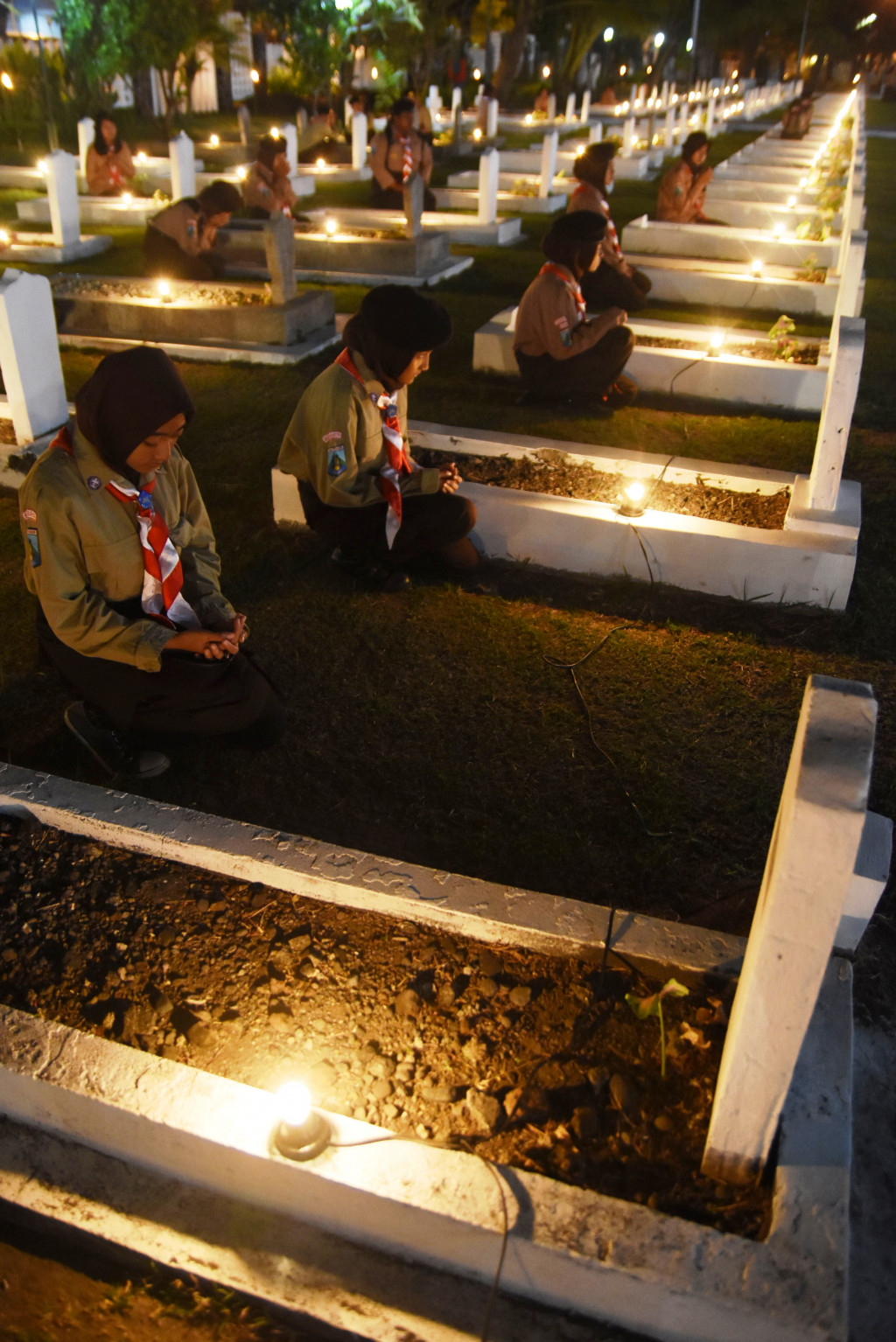 Beberapa anggota Pramuka berdoa di pusara makam pahlawan dalam renungan suci di TMP Kusuma Bangsa, Surabaya. Kegiatan untuk mengenang jasa para pahlawan kemerdekaan ini dipimpin Gubernur Jatim Soekarwo. ANTARA FOTO/M Risyal Hidayat