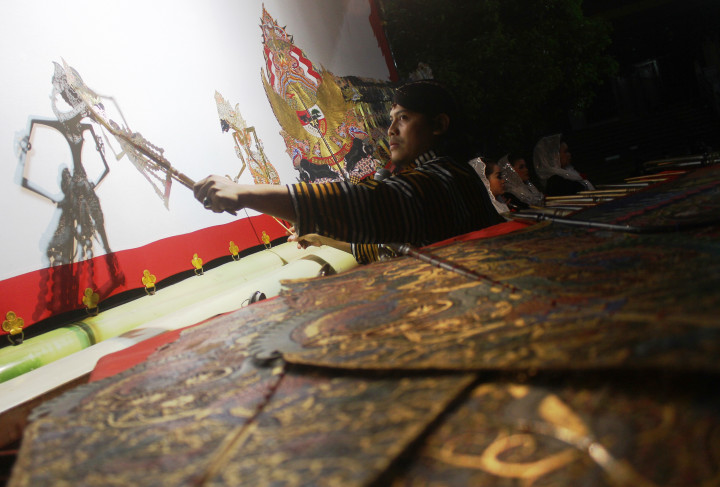 Dalang Ardi Purbo Antoro dengan gunungan Pancasila membawakan lakon Satria Tripama dalam Pagelaran Wayang Kulit di Klenteng En Ang Kiong, Malang. Kisah yang dibawakan merupakan bahan renungan peringatan HUT ke-72 RI melalui keragaman budaya. ANTARA FOTO/Ari Bowo Sucipto