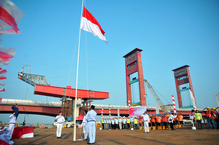 Sejumlah pekerja Light Rail Transit (LRT) melakukan upacara bendera di atas ponton di bantaran Sungai Musi Palembang, Sumatera Selatan. Untuk memperingati HUT ke-72 RI, Waskita Karya menggelar peringatan hari kemerdekaan dengan upacara dan sejumlah perlombaan bagi pekerja LRT di Palembang. ANTARA/Feny Selly