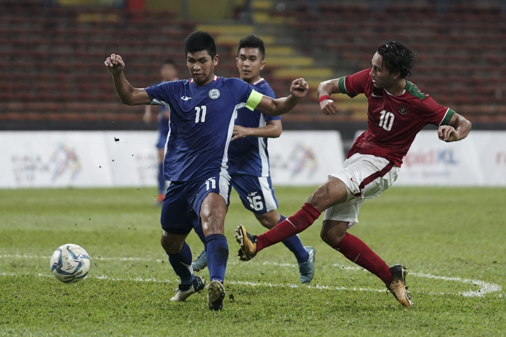 Penyerang Timnas U-22 Ezra Walian (kanan) berebut bola dengan pesepak bola Filipina U-22 Julian Mariano Clarino.