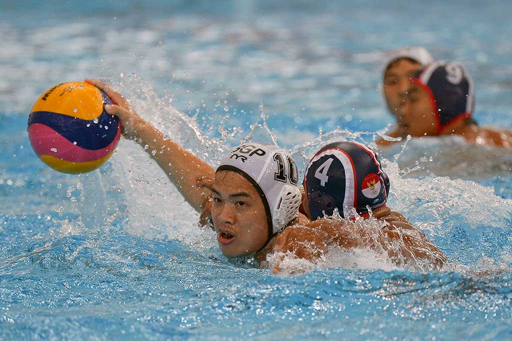 Atlet polo air Indonesia Silvester Goldberg Manik (kanan) berebut bola dengan atlet polo air Singapura Ang Wei Ming Sean pada pertandingan Polo Air putra SEA Games XXIX Kuala Lumpur di National Aquatic Centre, kawasan Stadion Bukit Jalil, Kuala Lumpur, Malaysia.