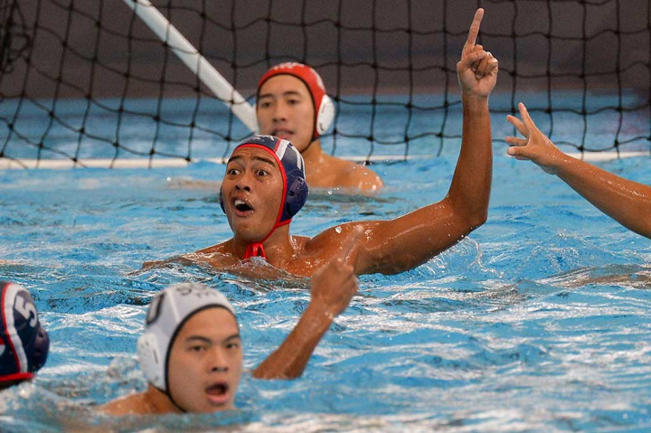 Atlet polo air Indonesia Ridjkie Mulia (tengah) melakukan selebrasi seusai memasukkan bola ke gawang tim polo air Singapura.