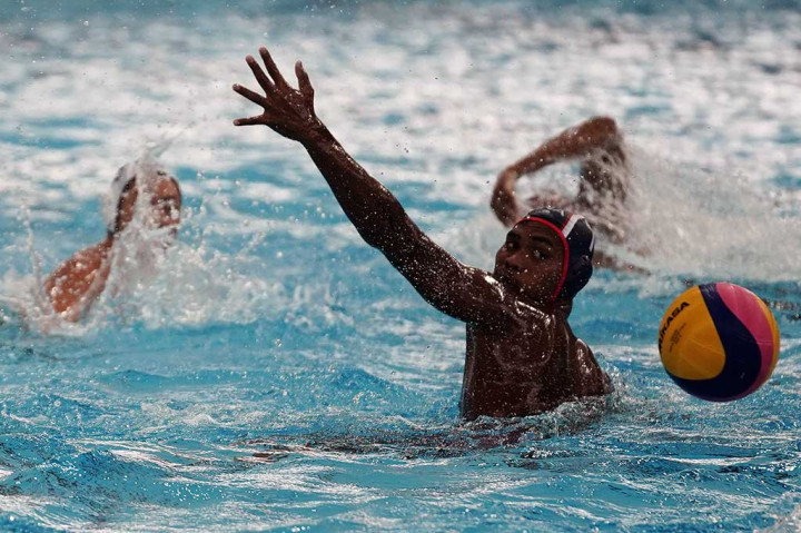 Atlet polo air IndonesiaYusuf Budiman (kanan) gagal menahan tembakan atlet polo air Singapura Chow Jing Lun.