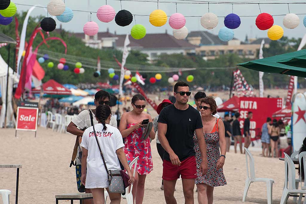 Wisatawan melintas di antara anjungan kuliner di arena Festival Kuta Sea Sand Land.