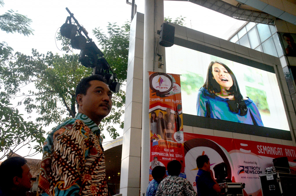 Abdul Kohar, pemimpin redaksi Metrotvnews.com, usai menyampaikan sambutan di panggung. Di layar monitor sedang ditampilkan video lagu Indonesia Raya yang selain dinyanyikan artis Maudy Ayunda juga antara lain oleh Mendagri Tjahjo Kumolo dan Walkot Bandung Ridwan Kamil.